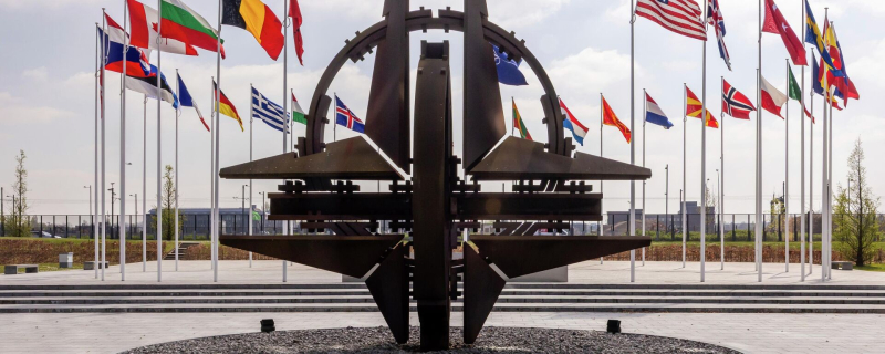 Флаги стран-участниц НАТО и эмблема альянса перед штаб-квартирой НАТО в Брюсселе